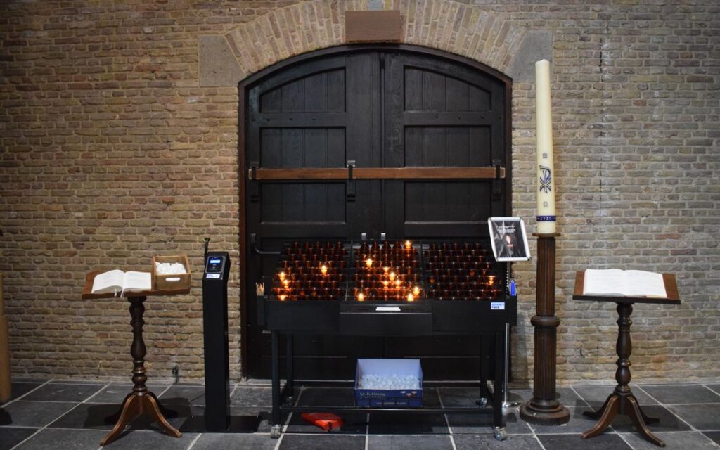 A serene church setting with lit candles, open prayer books, and traditional wooden furniture.