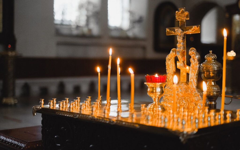 A serene church scene with lit candles and a golden crucifix, highlighting spiritual ambiance.