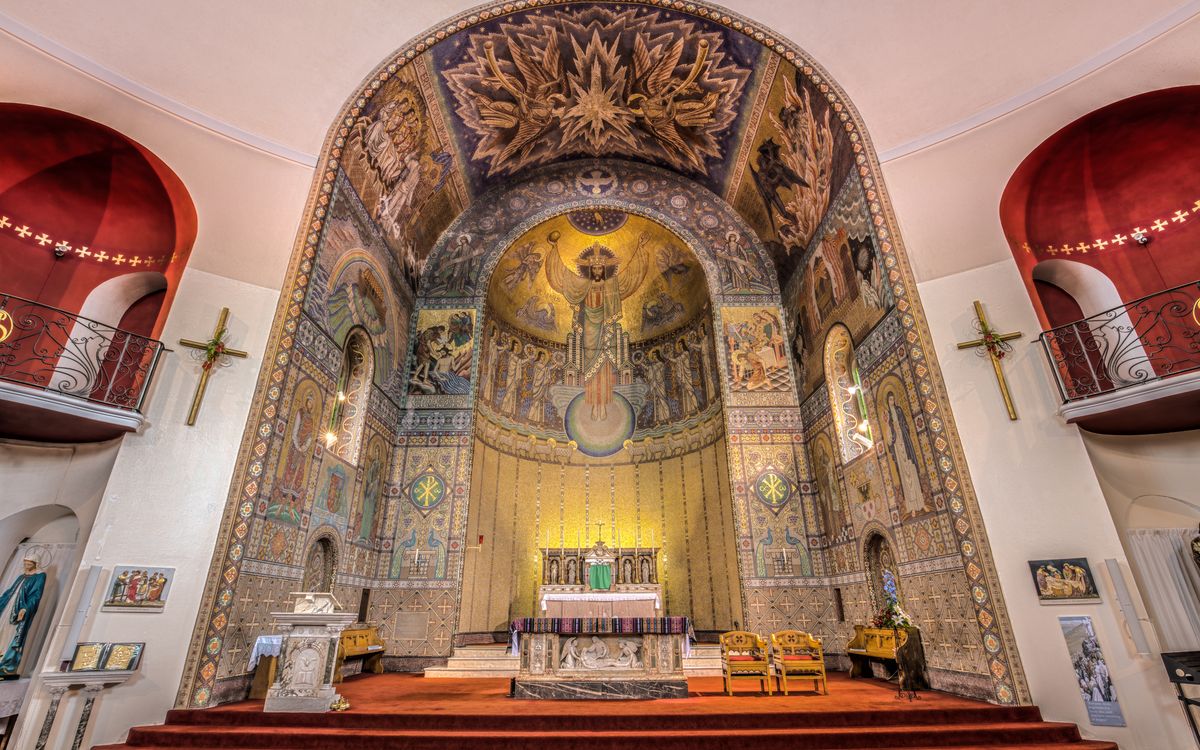 Beautiful interior view of the St John the Baptist Church in England, featuring intricate mosaics and architecture.