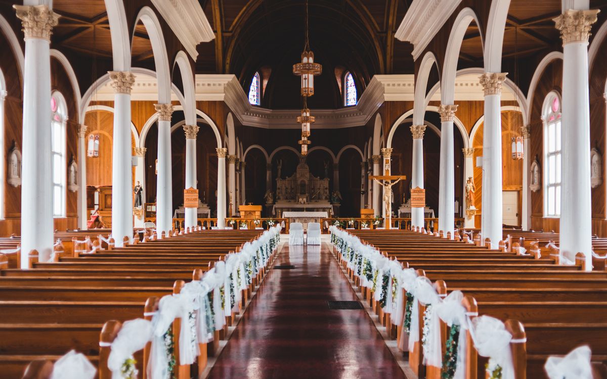 Elegant view of a church interior with decorated pews and arches, highlighting its architectural beauty.